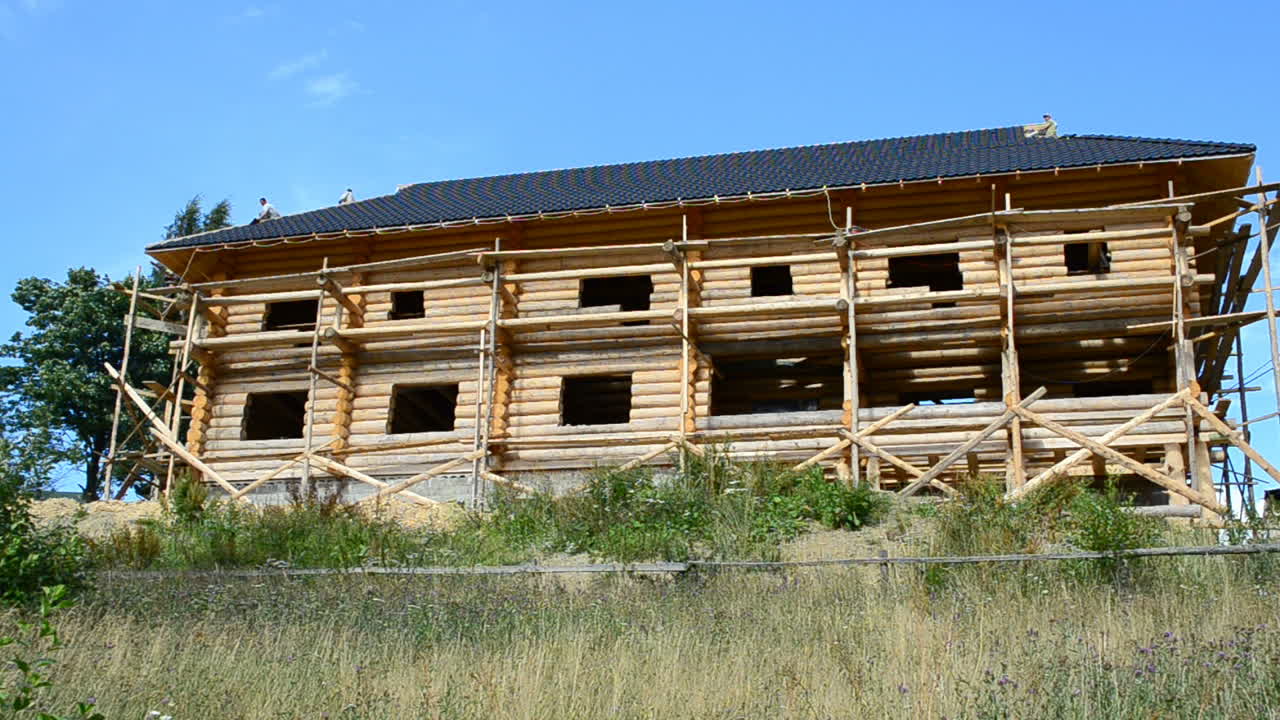 Bygging av trehuset. Tømmerstokker og takstein