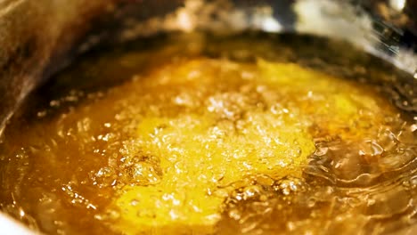 close-up of food frying in hot, bubbling oil, creating a golden, crispy texture.