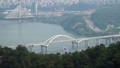 a view of the han river and the guri-amsa bridge in seoul, south korea as seen from them acha mountain hiking trail on a smoggy day