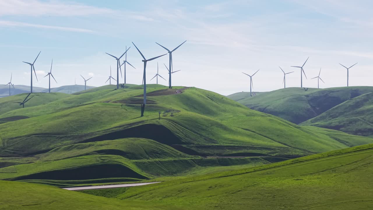 Left to right drone view of wind turbines generating power at Altamont Pass, Dublin, CA. Relevant to renewable energy, green technology, and California regional content
