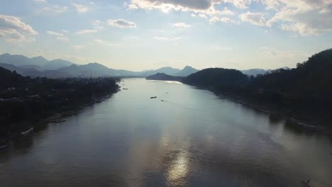 a drone shot at sunset above the mekong river in luang prabang, laos