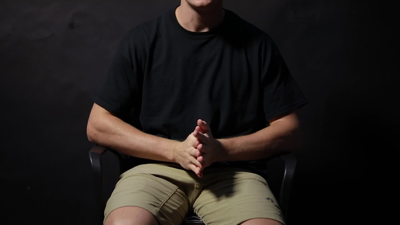 의자에 앉아 손을 비비는 남자의 슬로우 모션 샷