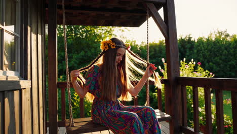 girl on a swing in a garden porch at sunset