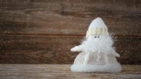 video composition with falling snow over desk with christmas decorations