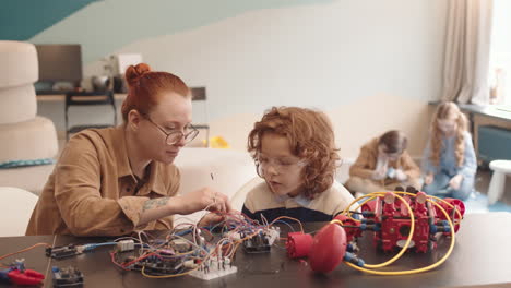 kids and teacher collaborating on robotics and electronics projects in a stem classroom