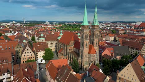 4k aerial drone video of the spectacular copper-clad spiers of the sebalduskirche church in downtown nurnberg, germany