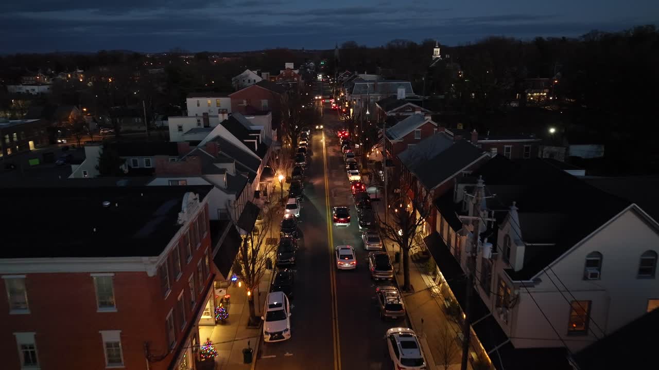 Luftfoto med drone av trafikk og mennesker i en liten, sjarmerende amerikansk by om natten