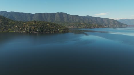 aerial view of aculeo lagoon in chile, surrounded by scenic mountains and lush greenery