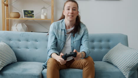mujer jugando videojuegos en un sofá