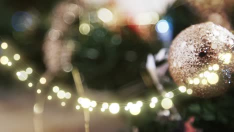 Animation-of-string-lights-and-blurred-christmas-tree-decorations