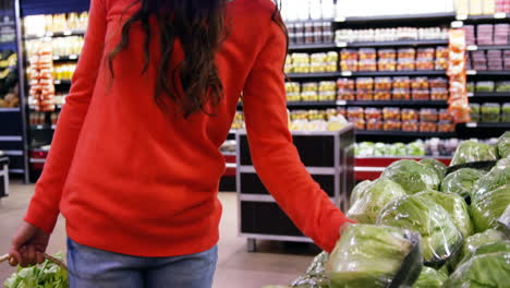 woman selecting vegetable from organic section