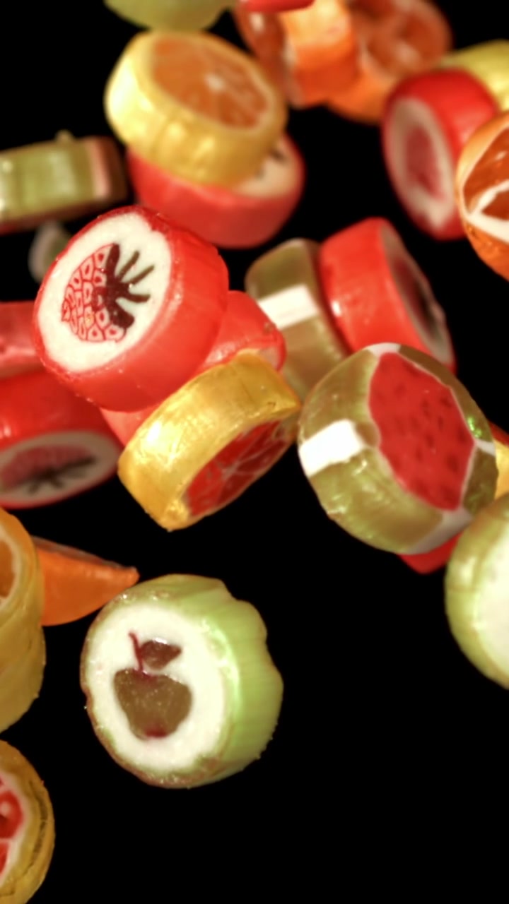 Bunte Fruchtbonbons fallen und hüpfen in Zeitlupe