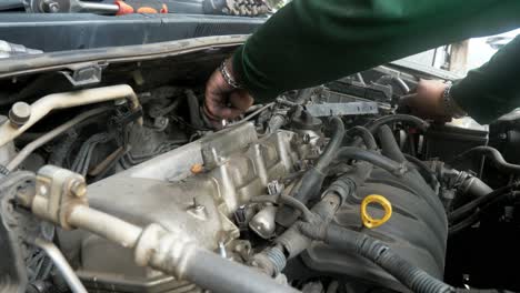 A-closer-shot-a-mechanic-working-on-the-engine-of-a-vehicle-in-a-repair-shop-in-Bangkok,-Thailand