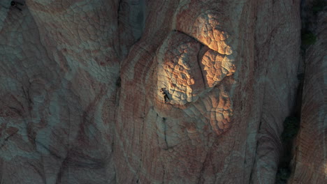 top down aerial view, woman lying on amazing hilly sandstone formation patterns