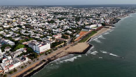 early morning aerial footage shows the city from the water. the entirety of puducherry, a lighthouse. the bengal bay waves. aerial footage of the city and the sea near tamil nadu