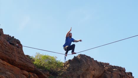 atleta de línea alta caminando en slackline en las montañas 4k