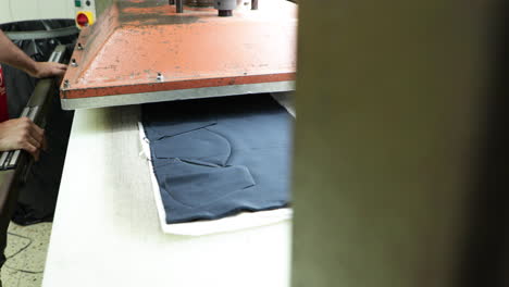 An-Automated-Molding-Machine-Molding-Blue-Cotton-Fabric-In-Making-Face-Masks-In-A-Sew-Factory-During-Covid-19-Outbreak---Medium-Shot-Pan-Left