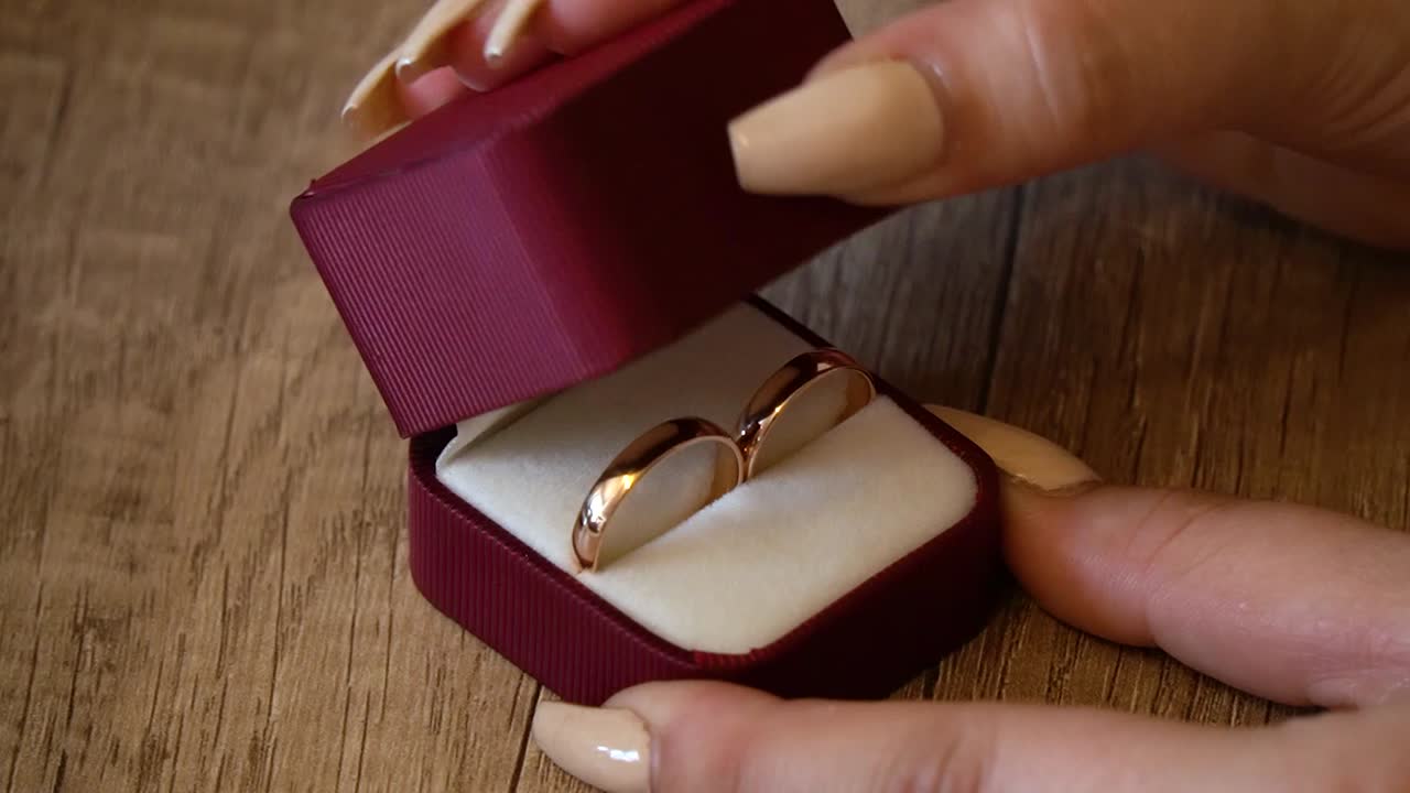 여자가 상자를 닫을 때 상자 안에 있는 결혼 반지를 닫으세요