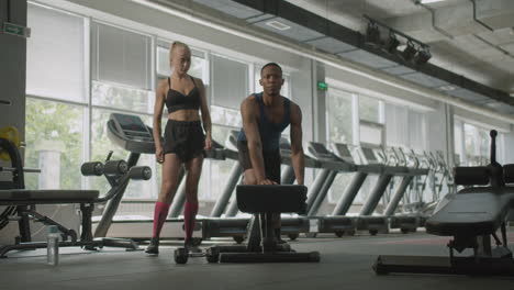 front view of caucasian female monitor and an athletic african american man in the gym.