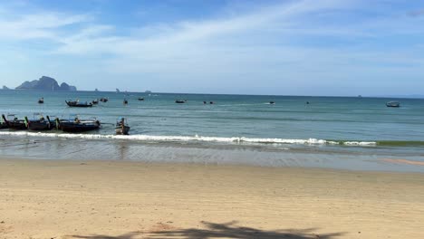 La-Orilla-Del-Mar-De-Andaman,-Playa-De-Arena,-Barcos-Tailandeses-De-Cola-Larga-Atracados-En-Krabi,-Tailandia