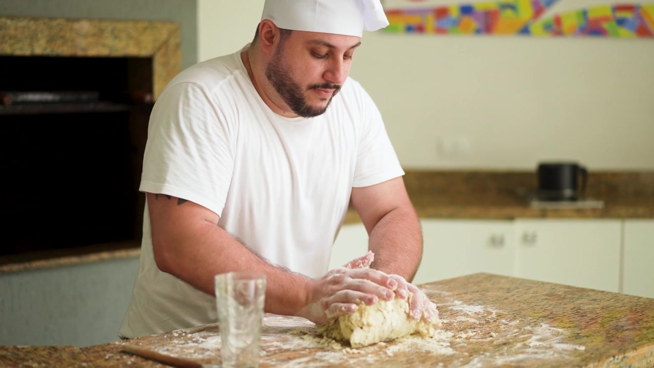 Szef kuchni umiejętnie formuje ciasto na pizzę na blacie, gotowe do nałożenia dodatków i upieczenia.
