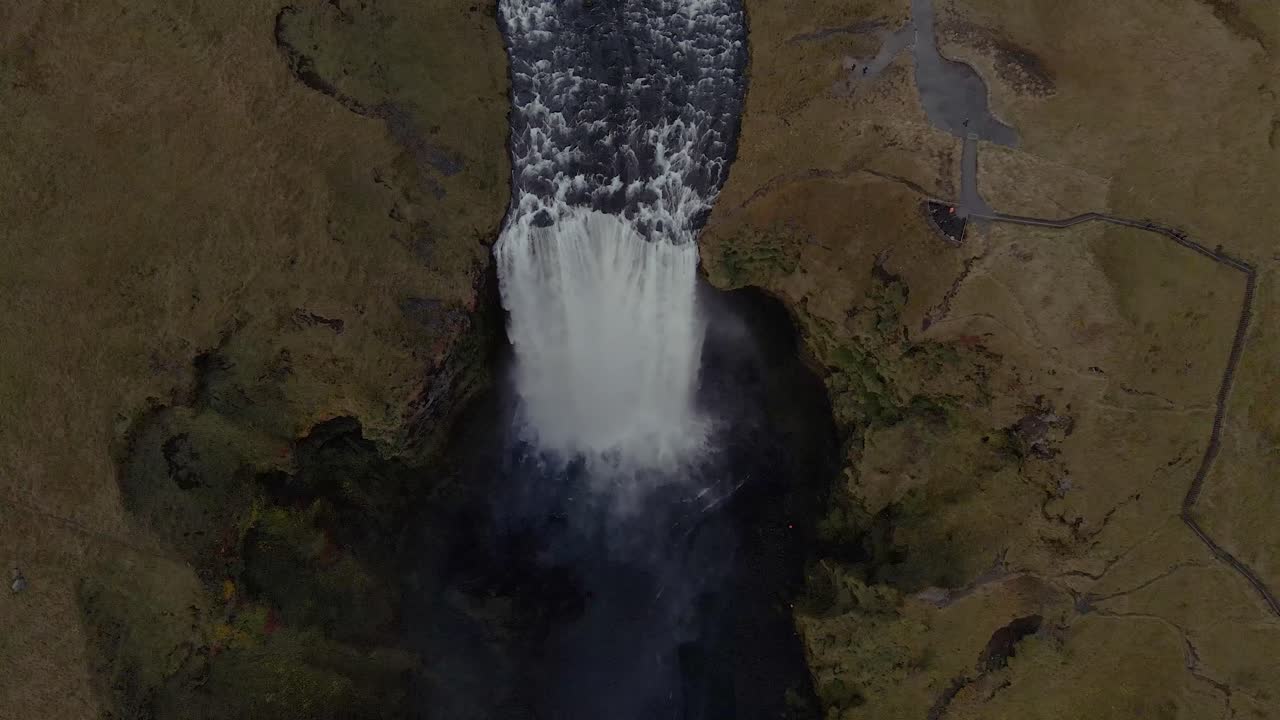 un dron se inclina sobre la cascada de skógafoss en islandia en un plano general