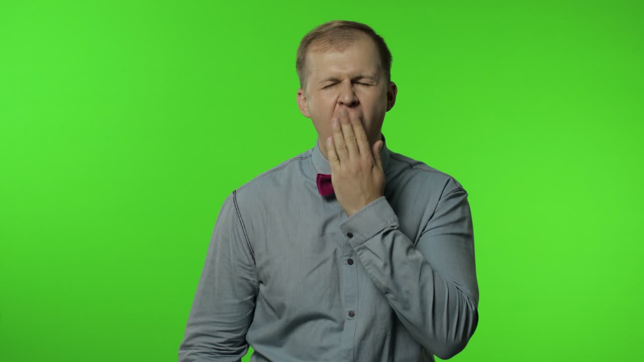 Tired man yawning and stretching hands, waking up, dreaming of rest, feeling lazy drowsy, insomnia