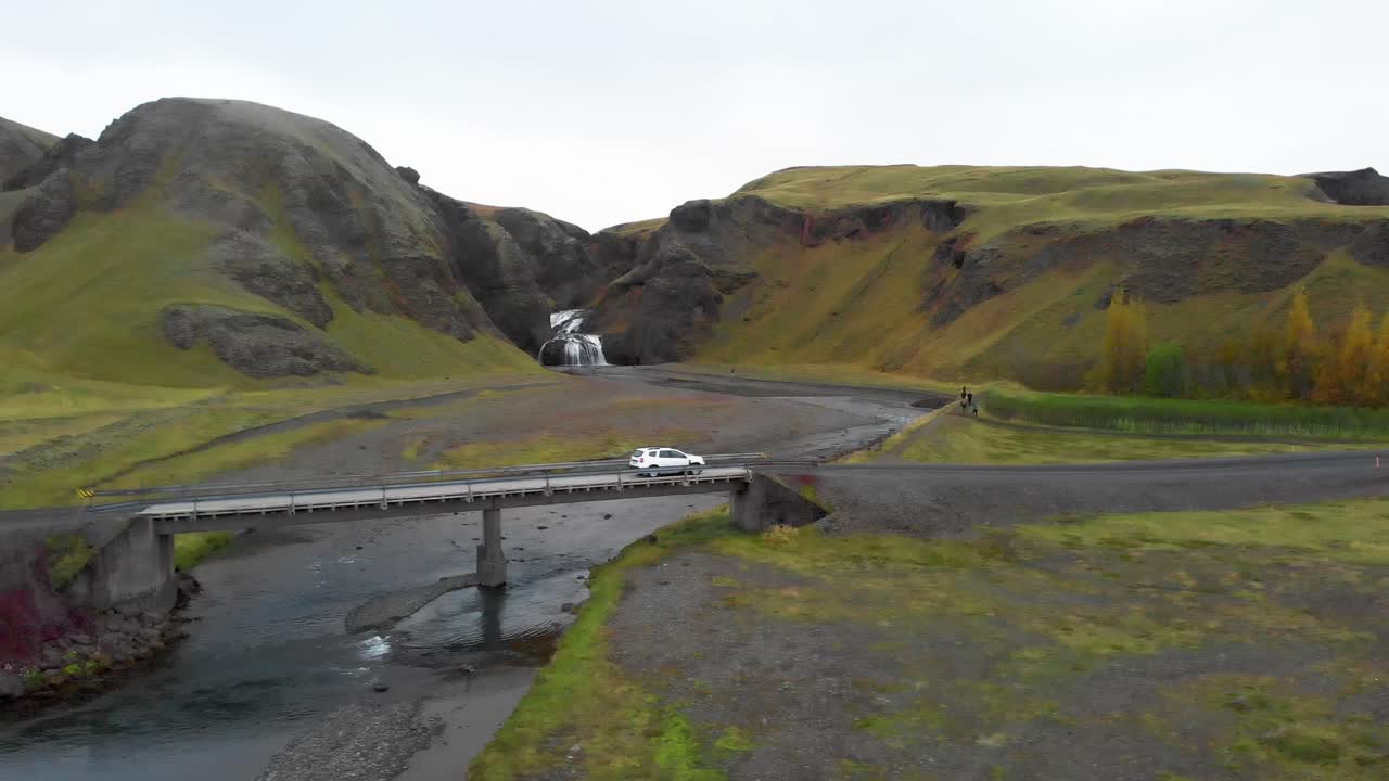 스토르나르포스 폭포 근처의 강을 가로지르는 도로 다리를 건너고 있는 자동차