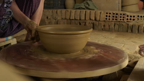 Close-up-of-traditional-Vietnam-pottery-turning-on-a-manual-foot-turned-table,-showcasing-the-skillful-use-of-clay