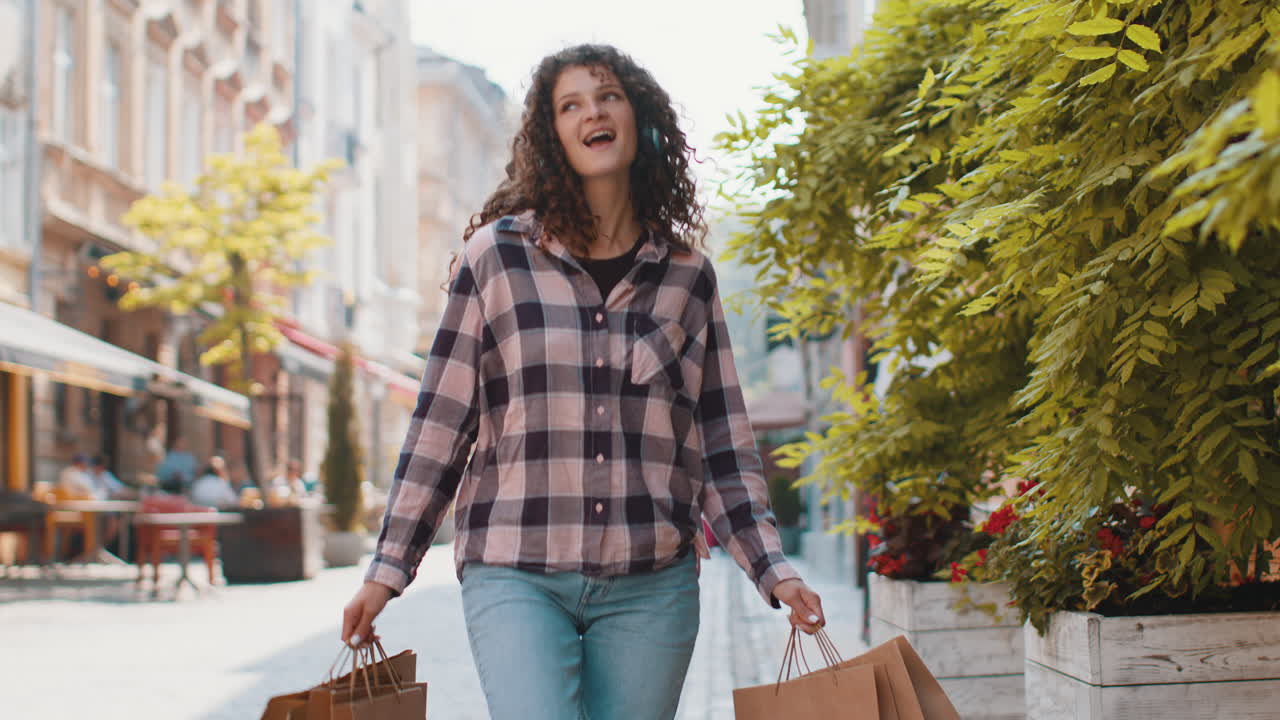 mujer joven feliz chica adicta a las compras consumidor después de la venta de compras con bolsas llenas caminando por la calle de la ciudad
