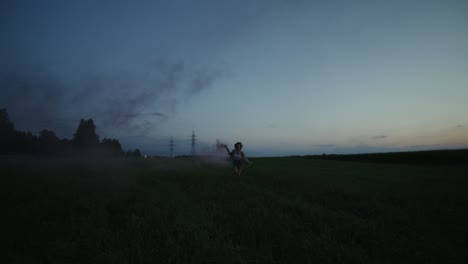 woman running in a field at dusk with pink smoke