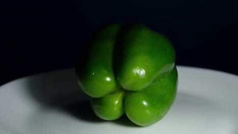 green bell pepper, spinning to the left while on a white plate