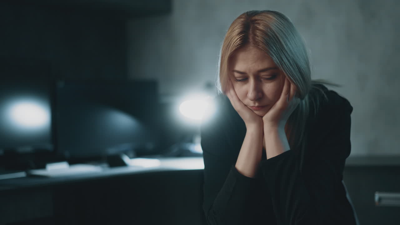 슬픈 여자가 손바닥에 기대어 일에서 소진으로 고통받고 있습니다.