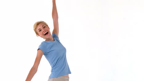 una mujer rubia saltando y sonriendo.