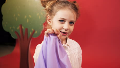 funny little girl with red hair posing in studio. emotions of the child. studio shooting of children.
