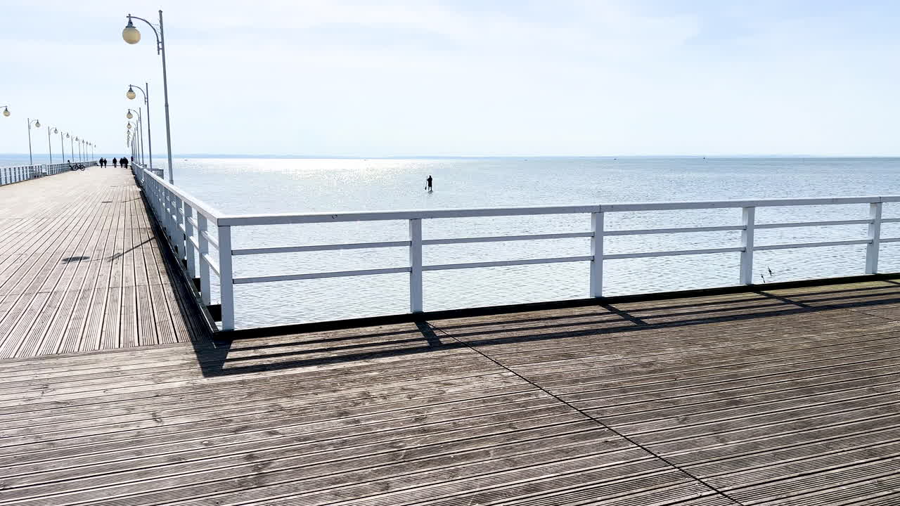 largo muelle de madera que se extiende en el mar tranquilo bajo un cielo despejado