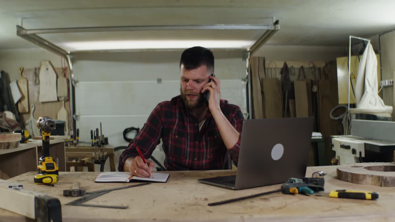 carpintero en el teléfono en el taller