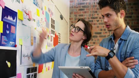 ejecutivo de negocios masculino y femenino interactuando a través de una tableta digital