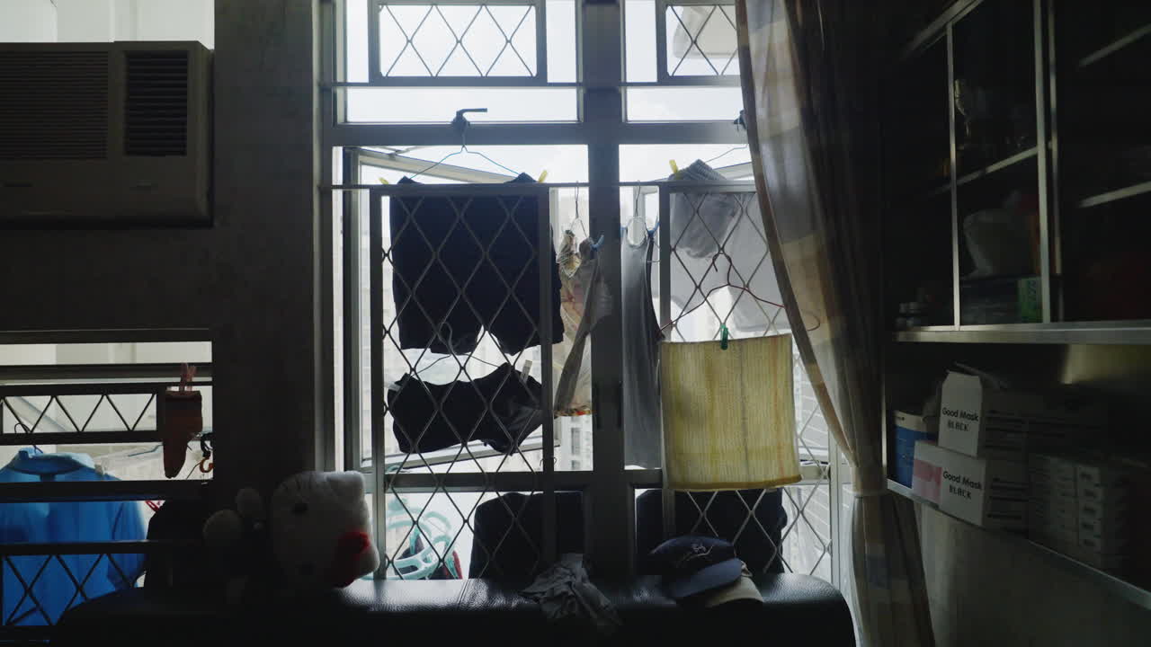 책장  ⁇ 의 아파트 창문 밖에서 매달려 있는 옷을 밀어 넣으세요.