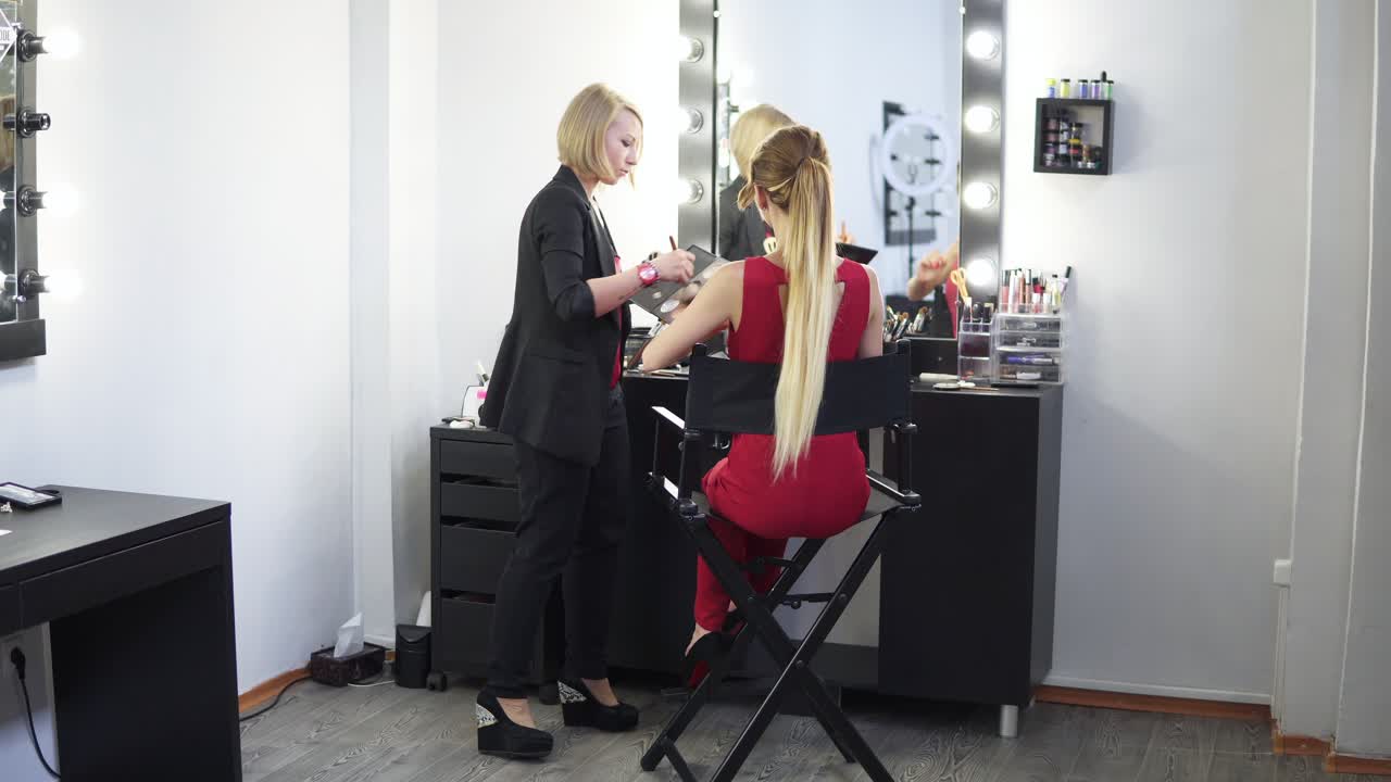 artista del trucco che applica una base tonale cosmetica sul viso usando un pennello e finendo il trucco. girato in 4k