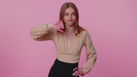 upset girl in beige blouse showing thumbs down sign gesture, disapproval, dissatisfied, dislike