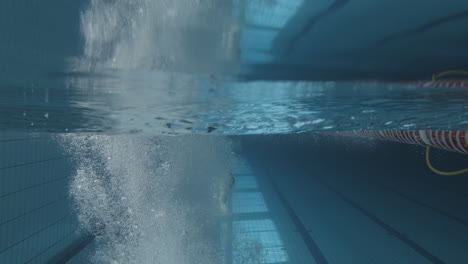 underwater shot of a young female swimmer jumping into the pool and diving in 1