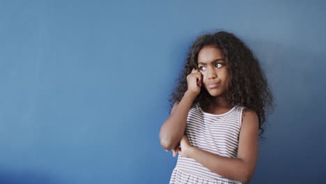 Happy-african-american-girl-raising-hands-and-celbrating-on-blue-background,-copy-space,-slow-motion