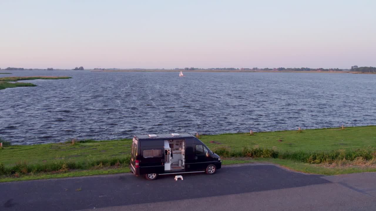 Tranquillità del lago Fluessen con camper e barca al tramonto, Frisia