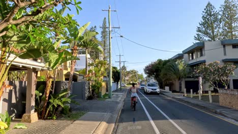 a cyclist rides along a peaceful suburban road.