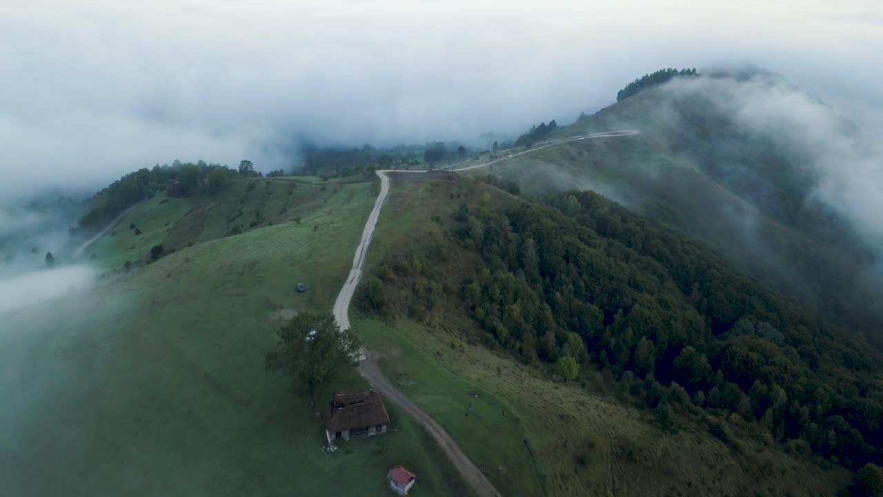 imágenes aéreas tomadas antes del amanecer en el campo de transilvania que muestran una casa tradicional abandonada en la cima de la colina más niebla en el valle y sobre los árboles