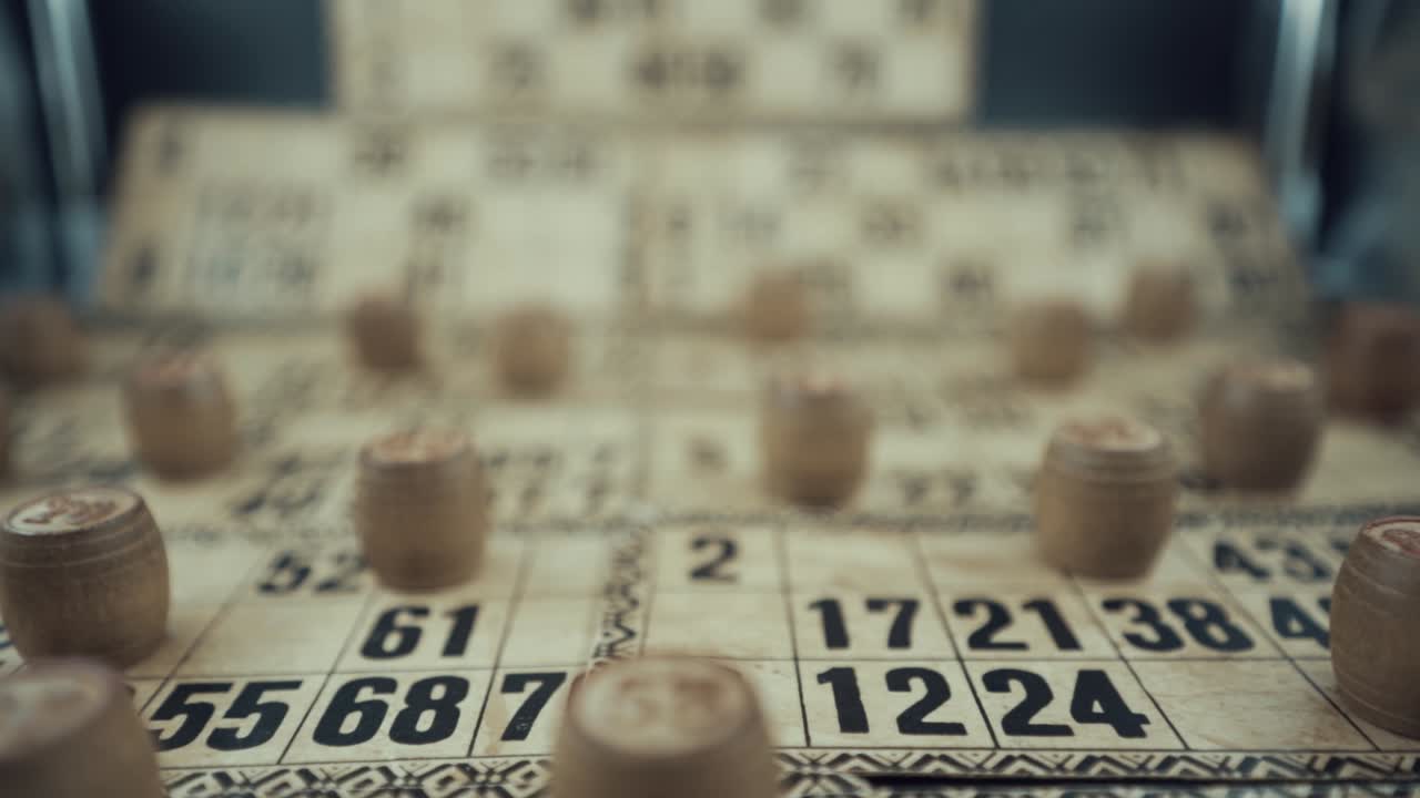 un video macro vertical de un tablero de bingo, luces de estudio, 120 fps, cámara súper lenta, dígitos de chips de madera, imágenes en bruto, juego de mesa de lotería vintage, números de cartas, movimiento suave de la grúa