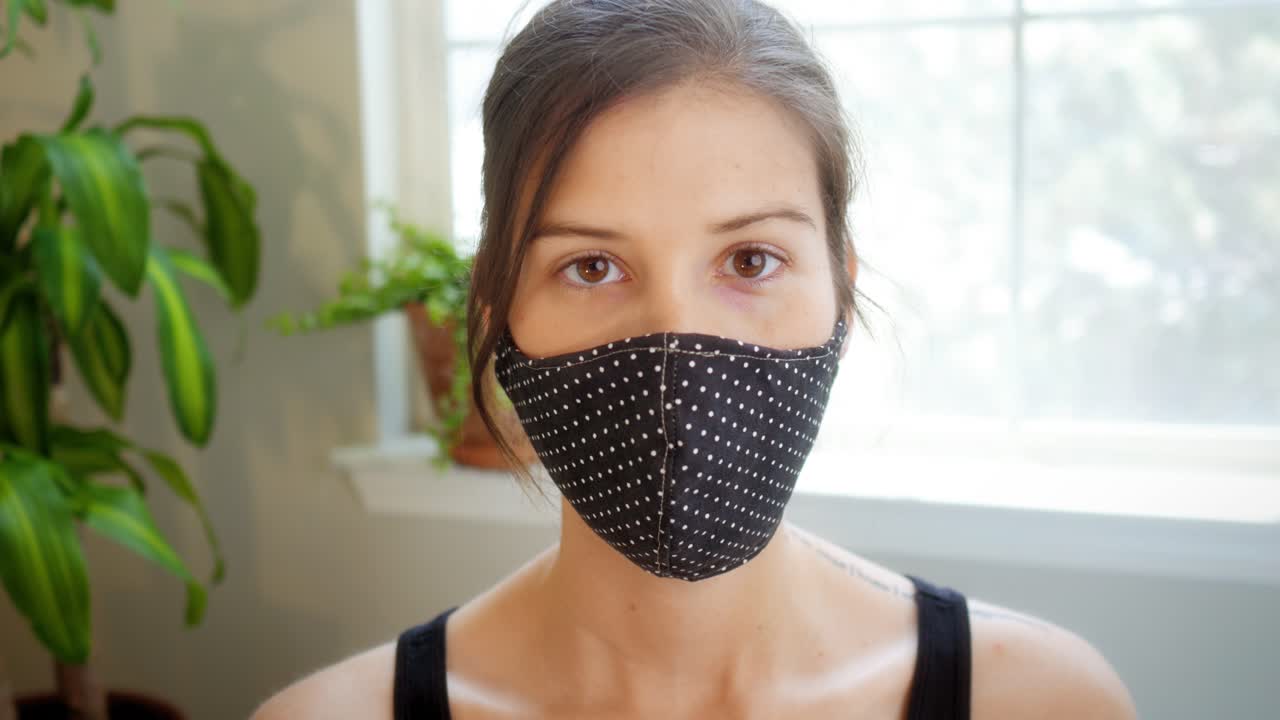 Beautiful woman removes her medical mask and smiles at the camera