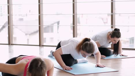 pregnant woman stretching legs with an instructor