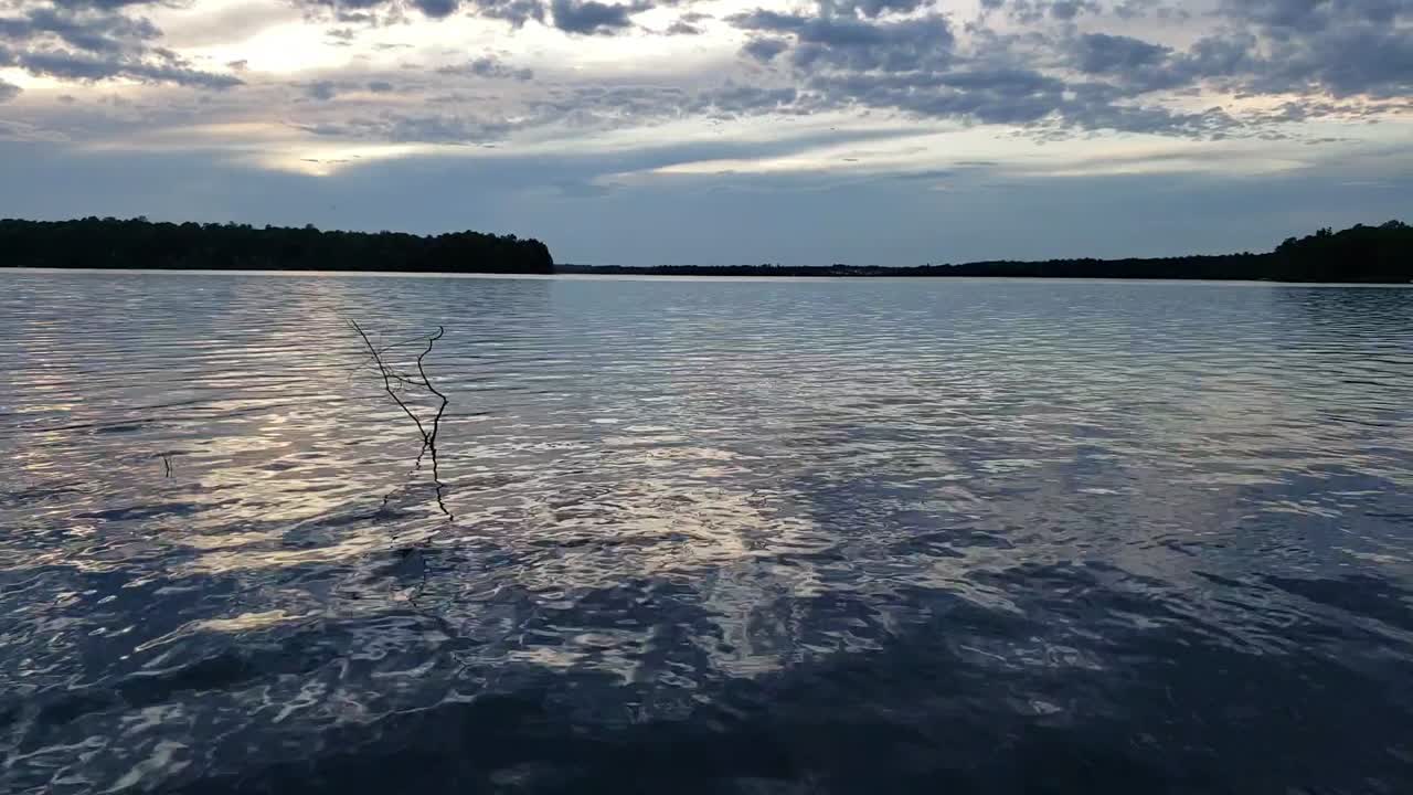 호수의 잔잔한 물 위에 아름다운 일몰의 동작 시간 경과